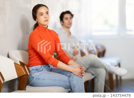 woman sits in line to sign up in school driving courses 143754479