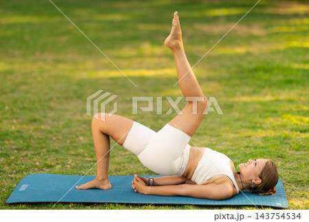 Girl enjoying outdoor yoga practice in green summer park Girl enjoying outdoor yoga practice in green summer park 143754534