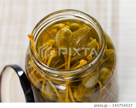 Glass jar with pickled green capers 143754537