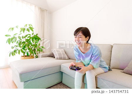 リビングでゲームを楽しむ若い女性 143754731