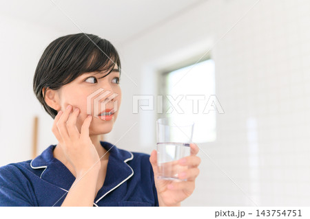洗面所で頬の痛みに悩む若い女性 洗面所で頬の痛みに悩む若い女性 143754751