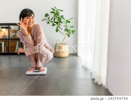 体重計に乗る女性 体重計に乗る女性 143754754