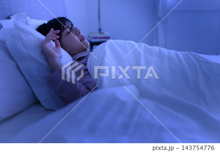 夜の寝室で眠りながら手を動かす女性の様子 夜の寝室で眠りながら手を動かす女性の様子 143754776