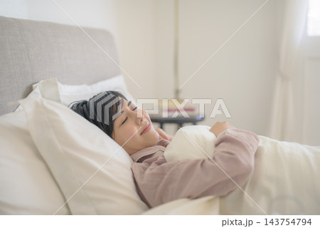 ベッドで微笑む女性、安らかな眠り ベッドで微笑む女性、安らかな眠り 143754794