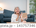 Senior asian woman applying neck cream looking in mirror. 143757346