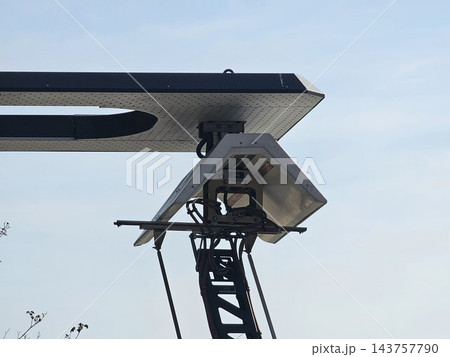 Raised pantograph contact mechanism beneath charging canopy 143757790