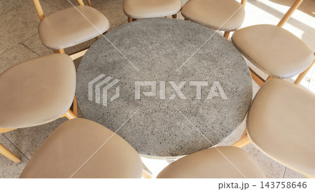 Round stone table surrounded by chairs in a dining area Round stone table surrounded by chairs in a dining area 143758646