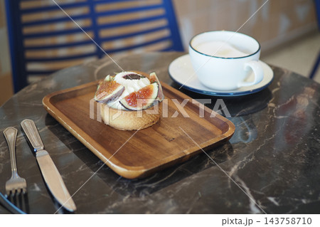 Fig-topped pastry and coffee served on a cafe table Fig-topped pastry and coffee served on a cafe table 143758710