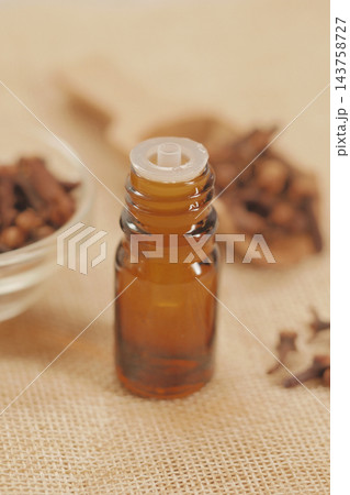Amber glass bottle with a dropper cap on a burlap surface 143758727