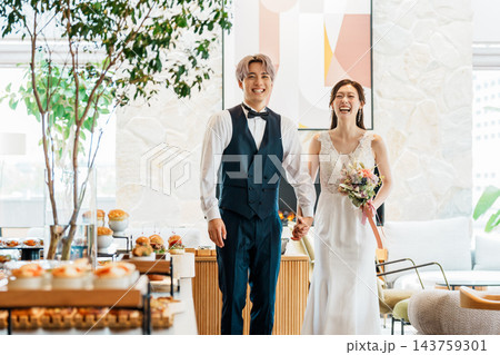 結婚式の披露宴で手を繋いで入場する新郎新婦 143759301