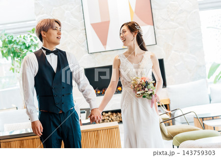 結婚式の披露宴で手を繋いで入場する新郎新婦 143759303