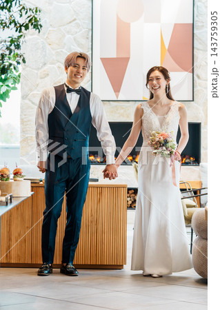 結婚式の披露宴で手を繋いで入場する新郎新婦 143759305
