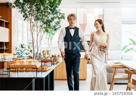 結婚式の披露宴で手を繋いで入場する新郎新婦 143759308