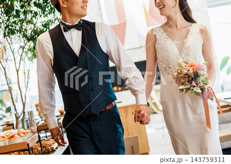 結婚式の披露宴で手を繋いで入場する新郎新婦 143759311