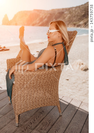 Relaxation, mature woman, coastal resort, blonde, sunglasses, wicker armchair, summer vacation, seaside balcony, elegant lifestyle 143759738