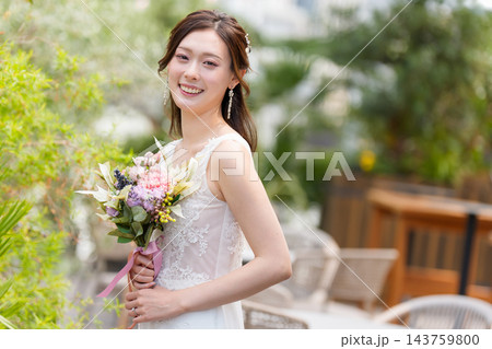 屋外のオープンチャペルでブーケを持ち微笑むウェディングドレス姿の花嫁 屋外のオープンチャペルでブーケを持ち微笑むウェディングドレス姿の花嫁 143759800