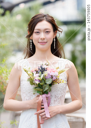 屋外のオープンチャペルでブーケを持ち微笑むウェディングドレス姿の花嫁 屋外のオープンチャペルでブーケを持ち微笑むウェディングドレス姿の花嫁 143759805