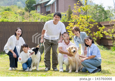 庭で犬と遊ぶ三世代家族 143760066