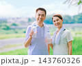 運動中に水分補給するシニア夫婦 143760326