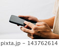 A hand holding a black cell phone isolated on white background, Man hand holding black smartphone mockup blank screen display 143762614
