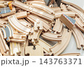 Wooden toy train tracks and railway construction pieces scattered on white background 143763371