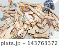 Wooden toy train tracks and railway construction pieces scattered on white background 143763372