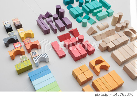 Colorful wooden building blocks scattered on white background for early childhood education Colorful wooden building blocks scattered on white background for early childhood education 143763376