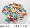 Colorful wooden building blocks scattered on white background for early childhood education 143763378