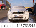 Silver car covered in thick active cleaning foam at self service wash station 143763548