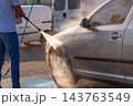 Crop view of a man washing his car by high pressure water gun 143763549
