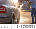 Man washing his car by high pressure water gun 143763551