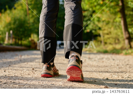 Close up of person walking on gravel hiking trail in nature Close up of person walking on gravel hiking trail in nature 143763611