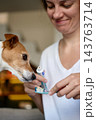 Woman preparing toothbrush with toothpaste for for dog teeth cleaning 143763714