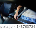 Woman fastening seat belt before driving a car 143763724