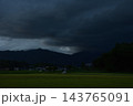 暗雲に覆われた山々と田園風景 143765091