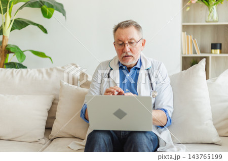 Senior man doctor with laptop talk on video call have consultation with patient. Professional senior mature healthcare expert examining patient online. Medicine healthcare medical checkup Senior man doctor with laptop talk on video call have consultation with patient. Professional senior mature healthcare expert examining patient online. Medicine healthcare medical checkup 143765199