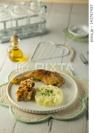 Roasted chicken leg, mashed potato, and savory bread pudding Roasted chicken leg, mashed potato, and savory bread pudding 143767497