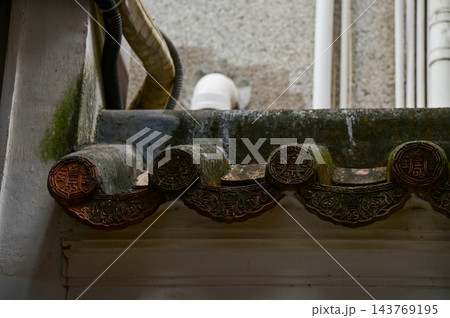 Close-up of the traditional, Chinese classic roof tiles of Chinese building, Chinese architecture in China Garden. Chinese historical building. Travel scene. Building exterior. Close-up of the traditional, Chinese classic roof tiles of Chinese building, Chinese architecture in China Garden. Chinese historical building. Travel scene. Building exterior. 143769195