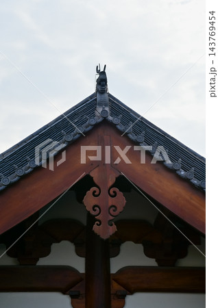 Close-up of the ornate decor on the Chinese classic roof of traditional building, Chinese architecture in China. Chinese folk religion landmark. Buddhist Temple or traditional building. Close-up of the ornate decor on the Chinese classic roof of traditional building, Chinese architecture in China. Chinese folk religion landmark. Buddhist Temple or traditional building. 143769454