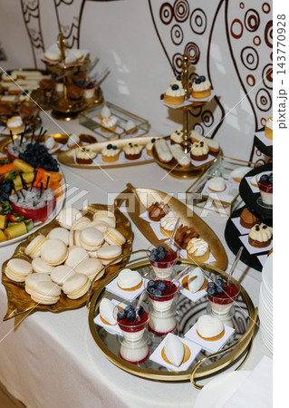 Dessert buffet table with macarons, fruits, and pastries Dessert buffet table with macarons, fruits, and pastries 143770928