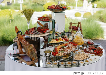 Wedding banquet catering a delicious buffet spread outdoors Wedding banquet catering a delicious buffet spread outdoors 143771117