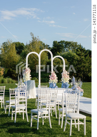 Outdoor wedding ceremony setup with floral arch decoration 143771118