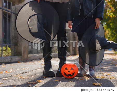 Mother and daughter enjoying Halloween trick or treat in neighborhood 143771375