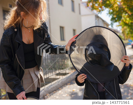 Mother and daughter enjoying Halloween trick or treat in neighborhood 143771561
