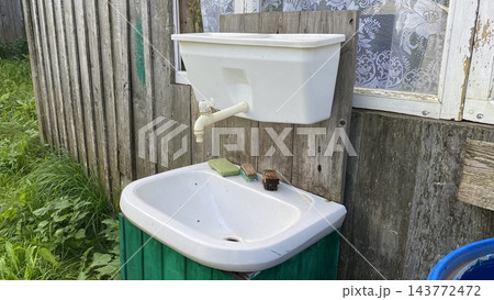 Outdoor washbasin with water tank and faucet at a rustic country house 143772472