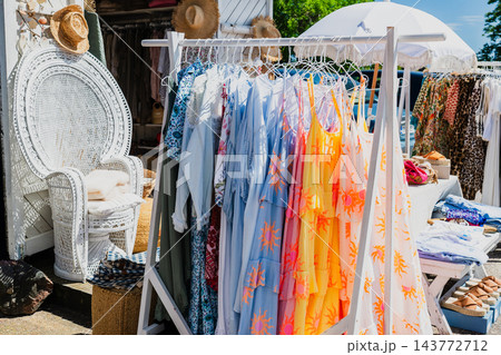 Stylish summer clothing collection on outdoor market rack with pastel linen fashion and casual apparel 143772712