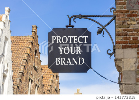 Protect your brand words symbol. Concept words Protect your brand on beautiful black road sign. Beautiful blue sky Brugge street background. Business and protect your brand concept. Copy space. Protect your brand words symbol. Concept words Protect your brand on beautiful black road sign. Beautiful blue sky Brugge street background. Business and protect your brand concept. Copy space. 143772819