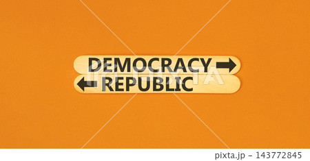 Democracy or republic words symbol. Concept words Democracy Republic on beautiful wooden sticks. Beautiful orange background. Business democracy republic concept. Copy space 143772845