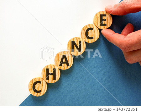 Chance symbol. Concept word Chance on beautiful wooden circles. Beautiful blue and white background. Businessman's hand. Business chance concept. Copy space. 143772851