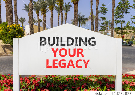 Building your legacy words symbol. Concept words Building your legacy on beautiful white information sign. Beautiful blue sky palm trees background. Business building your legacy concept. Copy space. Building your legacy words symbol. Concept words Building your legacy on beautiful white information sign. Beautiful blue sky palm trees background. Business building your legacy concept. Copy space. 143772877